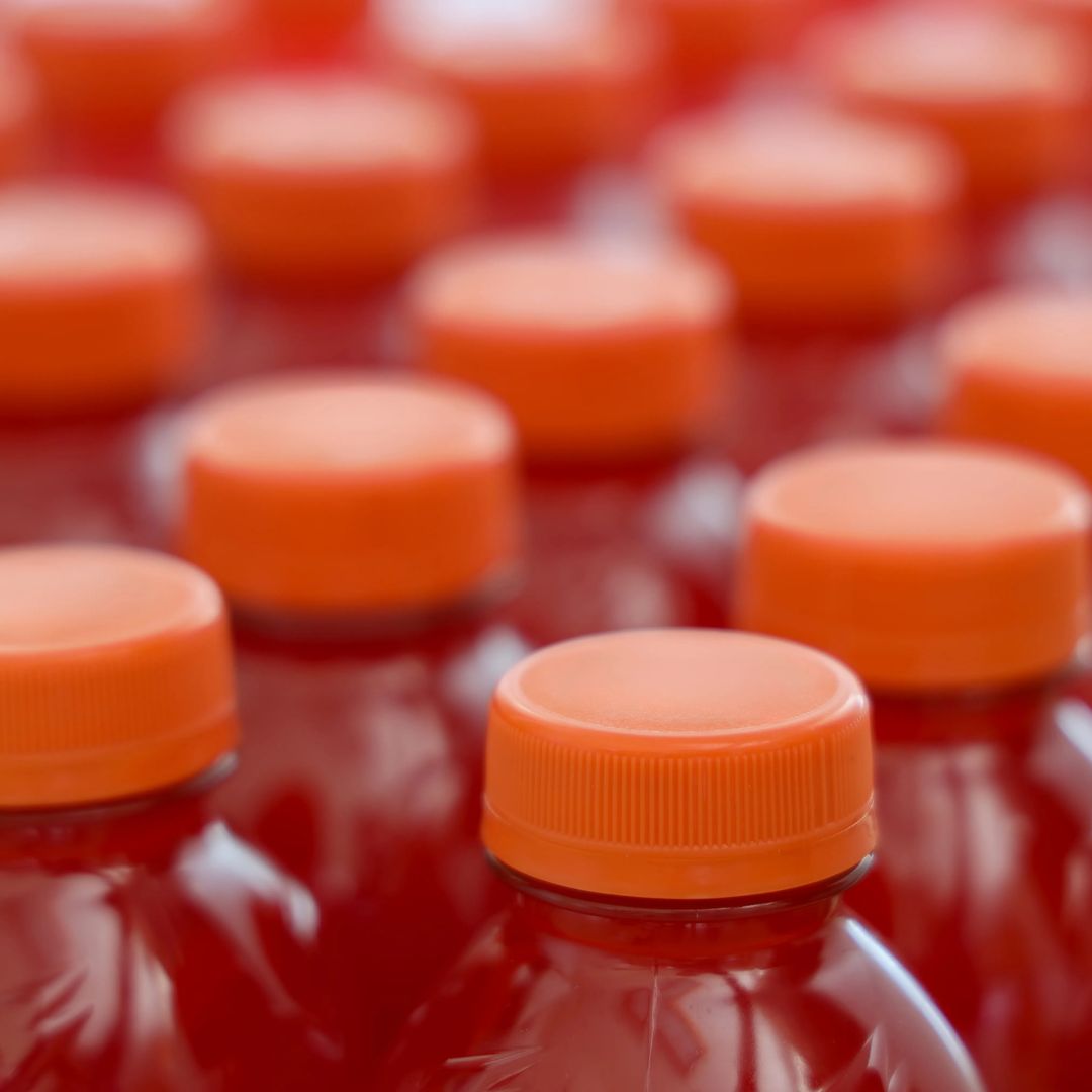 Close-up of plastic sports drink bottles with orange caps.